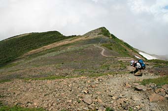 山頂から緩い下りのザラ道を行く