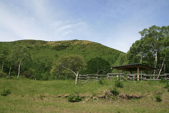 コンコンたいらには東屋があり、その正面、奥になだらかな山容をした角間山がそびえています