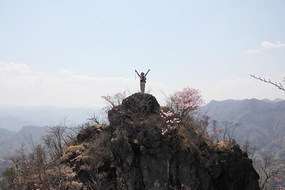 岩の上でバンザイしている写真