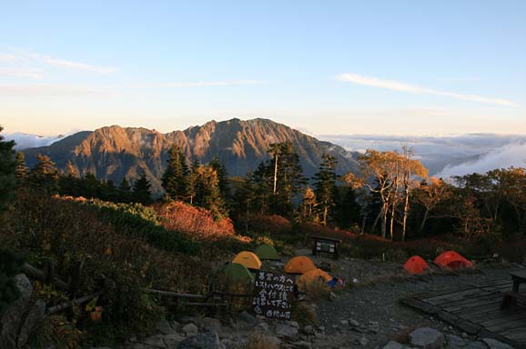 写真。夕日が山の斜面にあたり、赤く染まりきれいです。